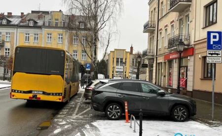 Osobówki na parkingu dla autokarów, autokar na jezdni