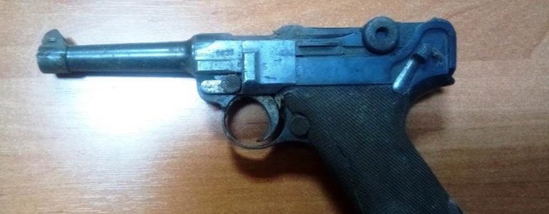 Stuletni pistolet w ścianie budynku