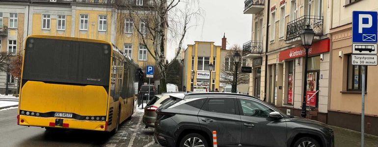 Osobówki na parkingu dla autokarów, autokar na jezdni